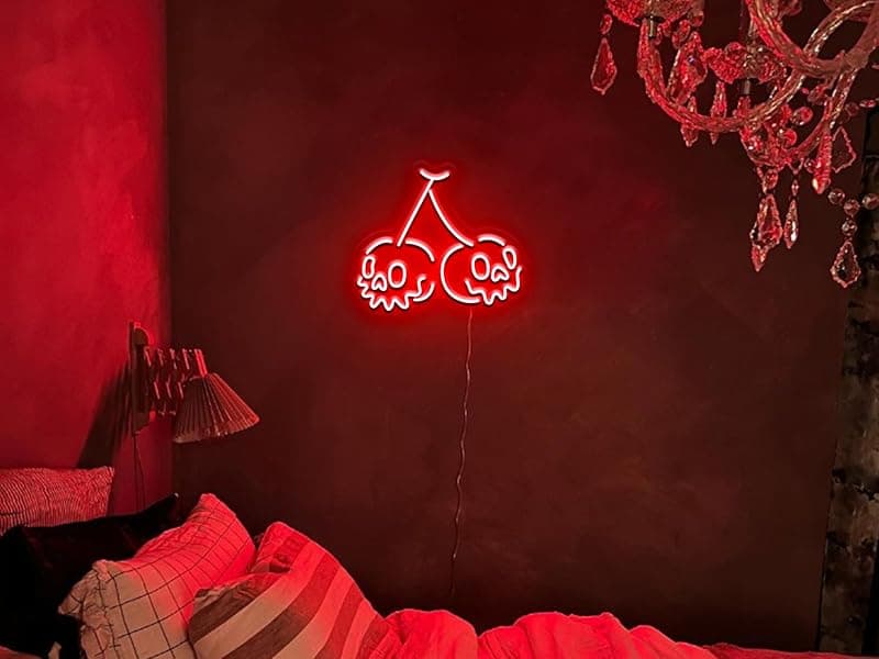 Room with cherry red neon sign and velvet pillows
